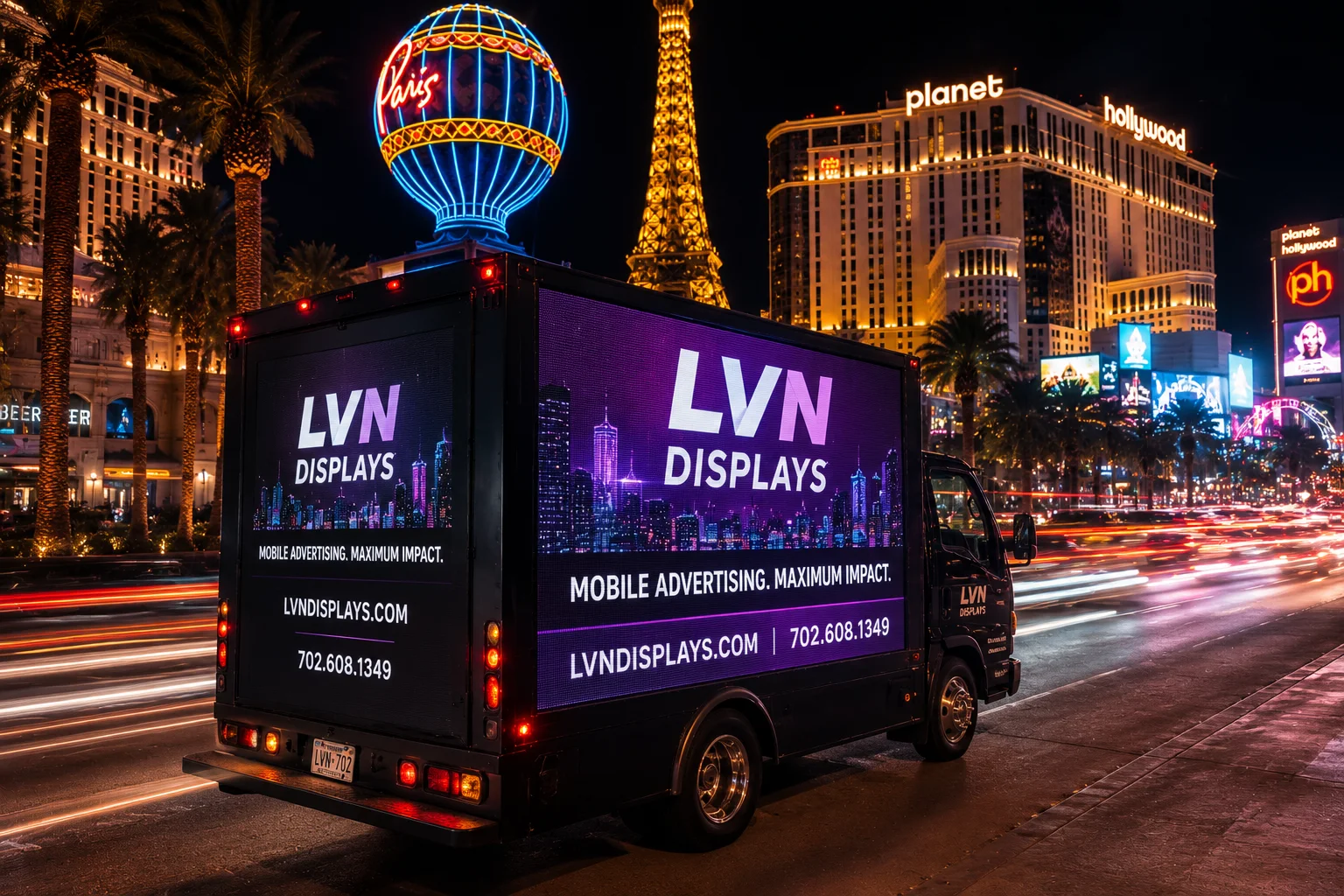 Rear three-quarter view of the LVN Displays LED billboard box truck on the Las Vegas Strip at night with its illuminated screen